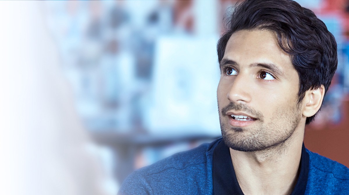 Man in office, speaking with co-workers